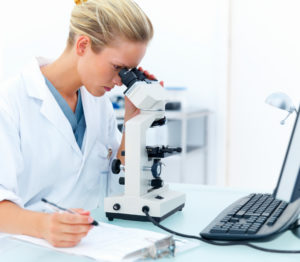 Lady analyzing air sampling samples under the microscope. 